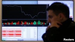 A man walks past an information screen on display inside the office of the Moscow Exchange in the Russian capital Moscow, March 14, 2014.