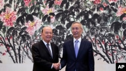 FILE - U.S. Commerce Secretary Wilbur Ross, left, chats with Chinese Vice Premier Liu He during a photograph session after their meeting at the Diaoyutai State Guesthouse in Beijing, China, June 3, 2018.