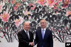 FILE - U.S. Commerce Secretary Wilbur Ross, left, shakes hands with Chinese Vice Premier Liu He as they pose for photographers after their meeting at the Diaoyutai State Guesthouse in Beijing, June 3, 2018.
