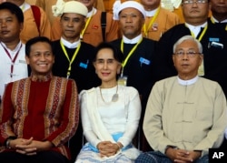 Myanmar's Foreign Minister Aung San Suu Kyi, center, sits with Myanmar's President Htin Kyaw, (Right), and Vice President Henry Van Hti Yu as they smile for a photo session following the Union Peace Conference-21st Century Panglong at the Myanmar International Convention Centre, Aug. 31, 2016, in Naypyitaw, Myanmar.