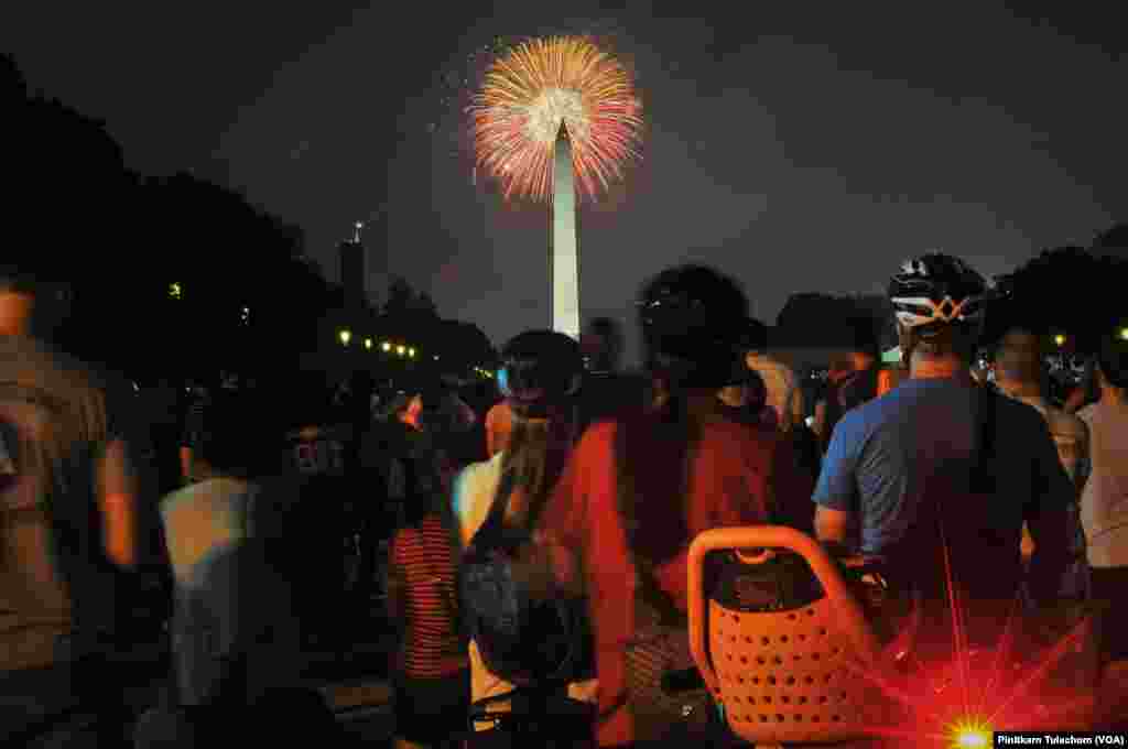 Orang-orang menonton Atraksi Kembang Api 4 Juli di National Mall, Washington, D.C., 4 Juli 2017.