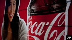 FILE - Image shows a Coca-Cola advertisement, July 16, 2012. The Indian subsidiary of Coca-Cola Co (KO.N) said on Friday it may have to close some bottling plants if the government pushes through a proposal that would subject fizzy drinks to a 40 percent "sin" tax, as part of a broader fiscal overhaul.