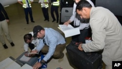 Samples brought back by the U.N. chemical weapons inspection team are checked in upon their arrival at The Hague, Netherlands, August 31, 2013.