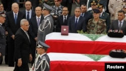 Lebanon's President Michel Suleiman pays his respects after placing honorary medals at the coffins of slain intelligence officer Wissam al-Hassan and his bodyguard Ahmed Sahyouni during an official ceremony to pay tribute their deaths, at the Internal Sec
