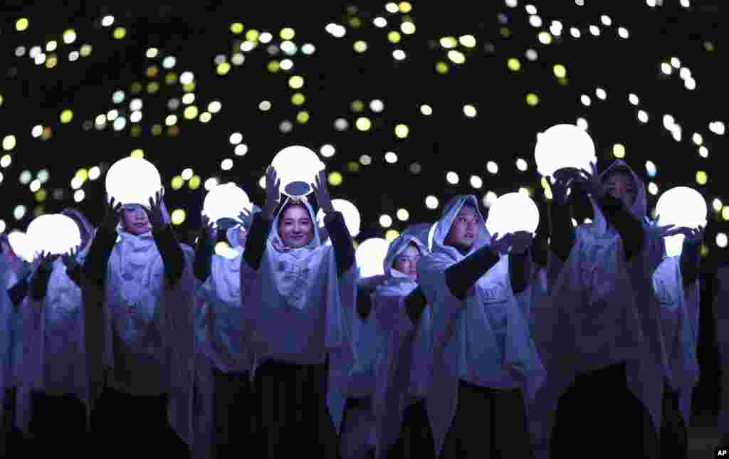 Performers carry lights during the closing ceremony of the 2018 Winter Olympics in Pyeongchang, Feb. 25, 2018.
