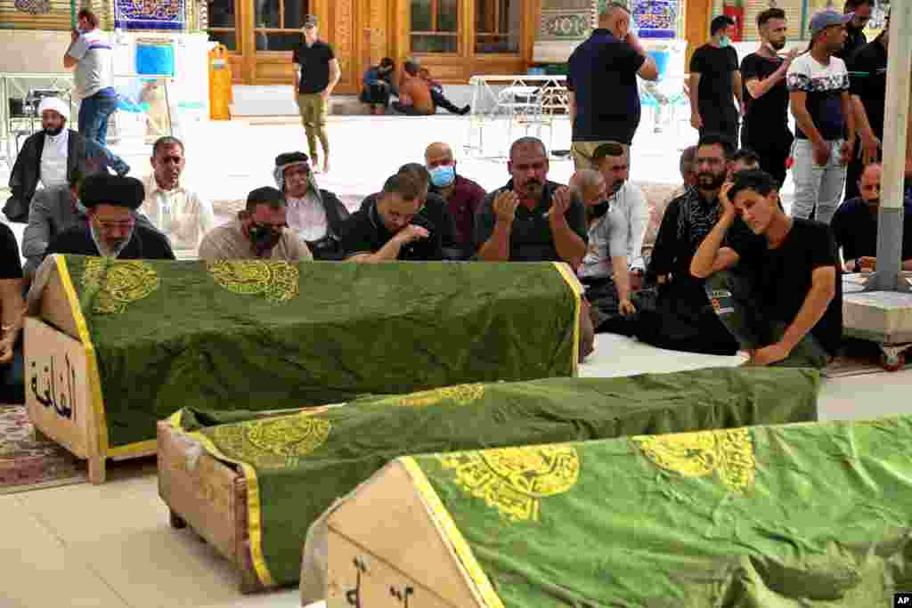 Mourners pray near the coffins of coronavirus patients who were killed in a hospital fire, during their funeral at the Imam Ali shrine in Najaf, Iraq. Iraq’s Interior Ministry said that over 80 people died and over 100 were injured in a catastrophic fire that broke out in the intensive care unit of a Baghdad hospital tending to severe coronavirus patients. 
