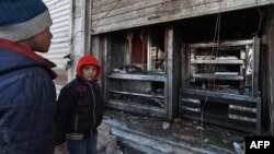 Syrian boys look at the destroyed grills outside a shuttered restaurant that was the site of a suicide attack targeting U.S.-led coalition forces in Manbij, Syria, the previous day, on Jan. 17, 2019. Islamic State claimed responsibility for the attack. 