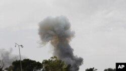 Smoke rises after an explosion, the cause of which was unclear, on Misrata's western front line, June 11, 2011