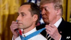 川普总统在白宫把“荣誉勋章”授予海军特种作战总军士长斯拉宾斯基。（2018年5月24日）
