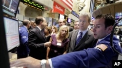 Rio Tinto CEO Tom Albanese, second from right, talks with specialist Michael Pistillo, right, as he visits the post that trades his company's stock on the floor of the New York Stock Exchange, 6 Oct 2010