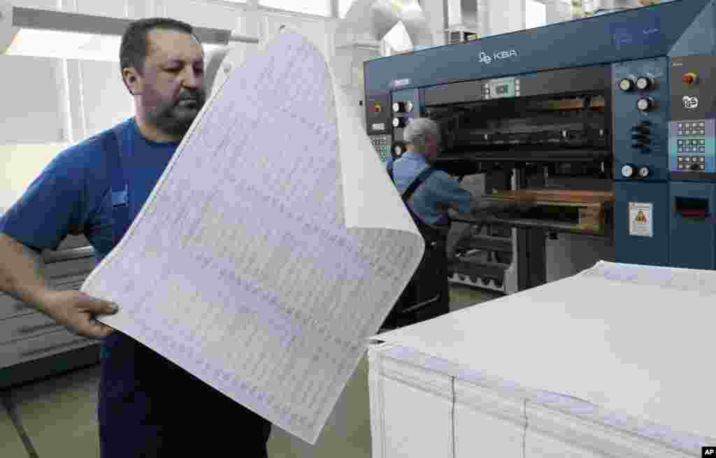 A worker at the state-owned printing house inspects a voting ballot for the May 25 snap presidential elections with 21 candidates taking part, in Kyiv, May 14, 2014.