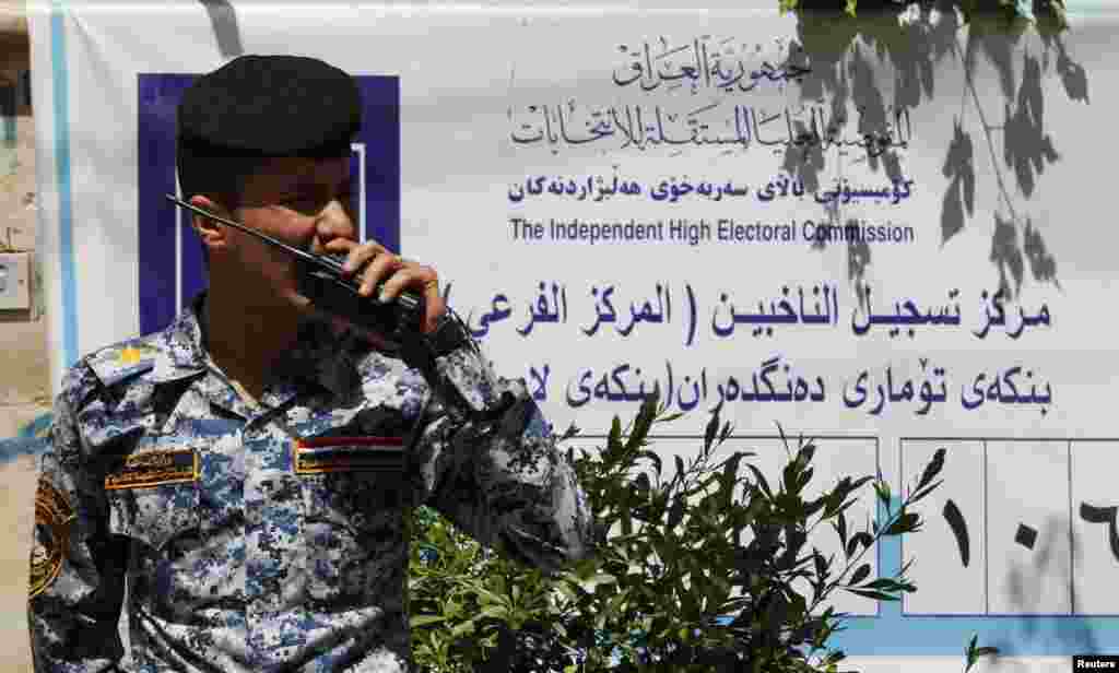 A policeman speaks on his walkie talkie at a polling centre in Baghdad April 19, 2013. The Iraqi government has tightened its security measures as the country prepares to provincial elections.