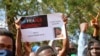 Thousands join a government-sponsored rally in Bamako, Mali, Jan. 14, 2021. Sign reads: 'France Out' , 'Mali is proud of its sons' and 'Thank you Colonel Assimi Goita.'