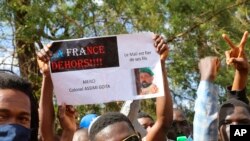 Thousands join a government-sponsored rally in Bamako, Mali, Jan. 14, 2021. Sign reads: 'France Out' , 'Mali is proud of its sons' and 'Thank you Colonel Assimi Goita.'