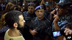 Protesters speak to police officers during a night rally to support the radical opposition group gunmen in the Republican Square in Yerevan, Armenia on July 31, 2016. 