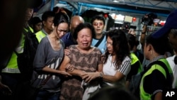 Relatives of Lim Saw Gaik, 49 and son, Neoh Jai Jun, 20, victims of Monday's bombing at a popular Bangkok shrine arrive to pay their final respects at the Neoh's home in Penang, Malaysia, Thursday, Aug. 20, 2015. 