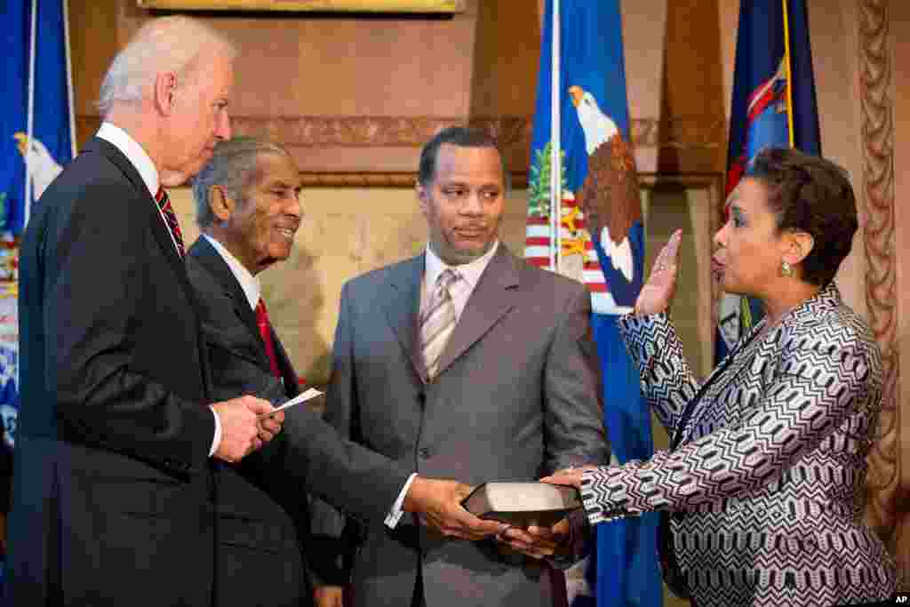 미국의 첫 흑인 여성 법무장관인 로레타 린치 장관(오른쪽)이 조 바이든 부통령과 아버지, 남편(왼쪽부터)이 지켜보는 가운데 취임 선서를 하고 있다.