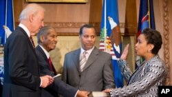 Wakil Presiden Joe Biden, didampingi ayah Loretta Lynch, Lorenzo Lynch (kedua dari kiri) dan suami Loretta, Stephen Hargrove, saat mengambil sumpah Jaksa Agung baru Loretta Lynch (27/4). (AP/Andrew Harnik)