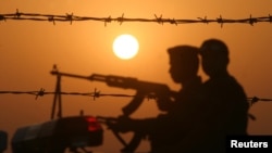 Iraqi soldiers conduct a patrol at sunset near the border with Kuwait in this file photo.