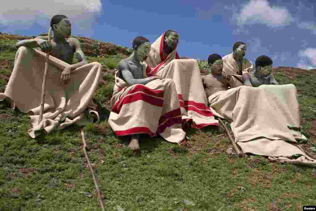 Youths sit on a field in Qunu, in the Eastern Cape, South Africa. Every year, thousands of youths leave their parents to spend weeks in the care of traditional leaders at an initiation school where they are circumcised, a rite of passage commonly referred to as &quot;Ukwaluka&quot; or &quot;going to the mountain&quot;.