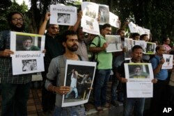 FILE - Indian journalists hold placards protesting against the attack on journalists and the arrest of Shahidul Alam, a renowned photographer and Bangladeshi activist as they gather outside Press Club in Kolkata, India, Aug. 8, 2018.