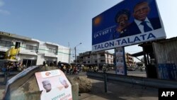 Panneau d'affichage de campagne du président sortant Patrice Talon et de sa vice-présidente Mariam Talata, face à l'affiche de campagne de l'opposition Corentin Kohoue et de la vice-candidate Irene Agossa, à Cotonou le 7 avril 2021.