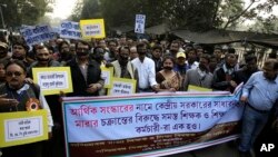 Members of West Bengal Teachers and Allied Educational Employees Federation walk in a procession protesting the demonetization of high-value bills in Kolkata, India, Wednesday, Dec. 28, 2016.