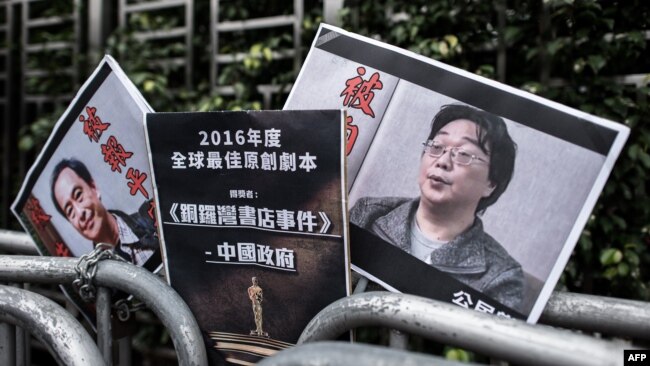 资料照:香港抗议者在北京驻香港机构中联办前手举铜锣湾书店失踪老板桂民海的照片。 (2016年1月19日)