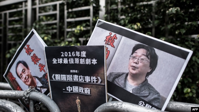 資料照:香港抗議者在北京駐香港機構中聯辦前手舉銅鑼灣書店失蹤老闆桂民海的照片。 (2016年1月19日)