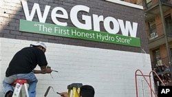 Workers put the finishing touches on the side of a building that will house a weGrow store in preparation for its opening on April 6, in northeast Washington, DC, March 29, 2012.