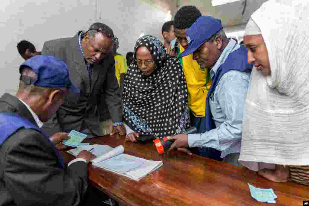 Election officials verify voters&#39; cards as people wait to vote in general election, in Addis Ababa, May 24, 2015.