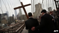 Members of the Archdiocese of New York and the Diocese of Brooklyn lead the Way of the Cross procession over the Brooklyn Bridge in New York City, April 3, 2015. 
