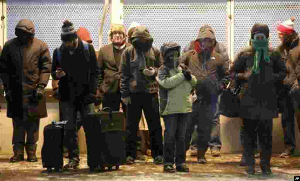 Commuters gather under warming lamps on one of Chicago's famous "El" lines as they experience wind chills expected to reach far below zero, Jan. 6, 2014.