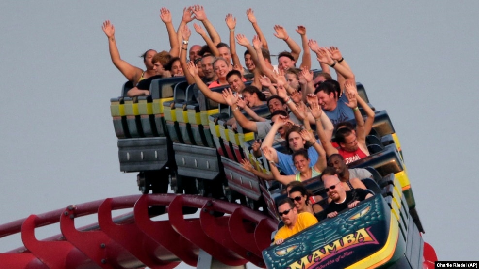 People ride a roller coaster at Worlds of Fun amusement park Saturday, June...