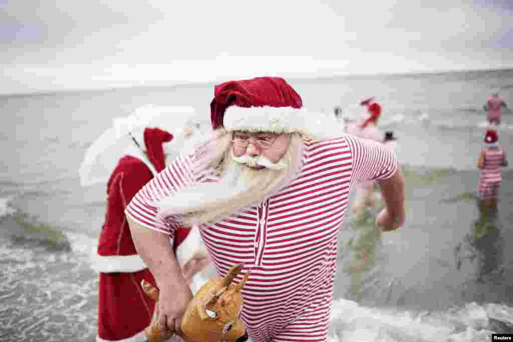 Participants of the World Congress of Santa Clauses 2015 take part in the annual swim at Bellevue beach, north of Copenhagen, Denmark.