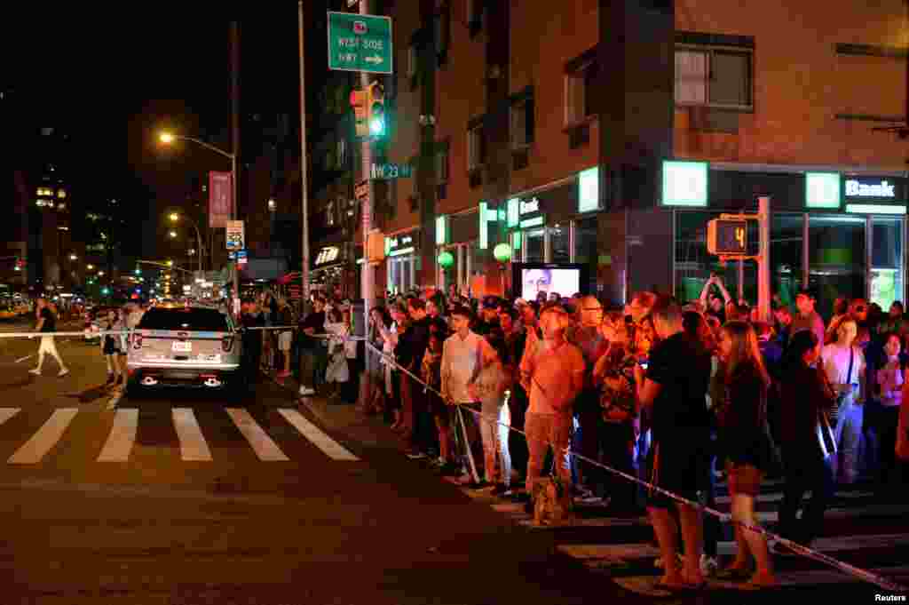 Onlookers stand behind a police cordon near the site of an explosion in the Chelsea neighborhood of Manhattan, New York, Sept. 17, 2016.