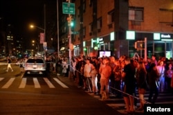 Onlookers stand behind a police cordon near the site of an explosion in the Chelsea neighborhood of Manhattan, New York, Sept. 17, 2016.