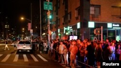 Onlookers stand behind a police cordon near the site of an explosion in the Chelsea neighborhood of Manhattan, New York, Sept. 17, 2016. 