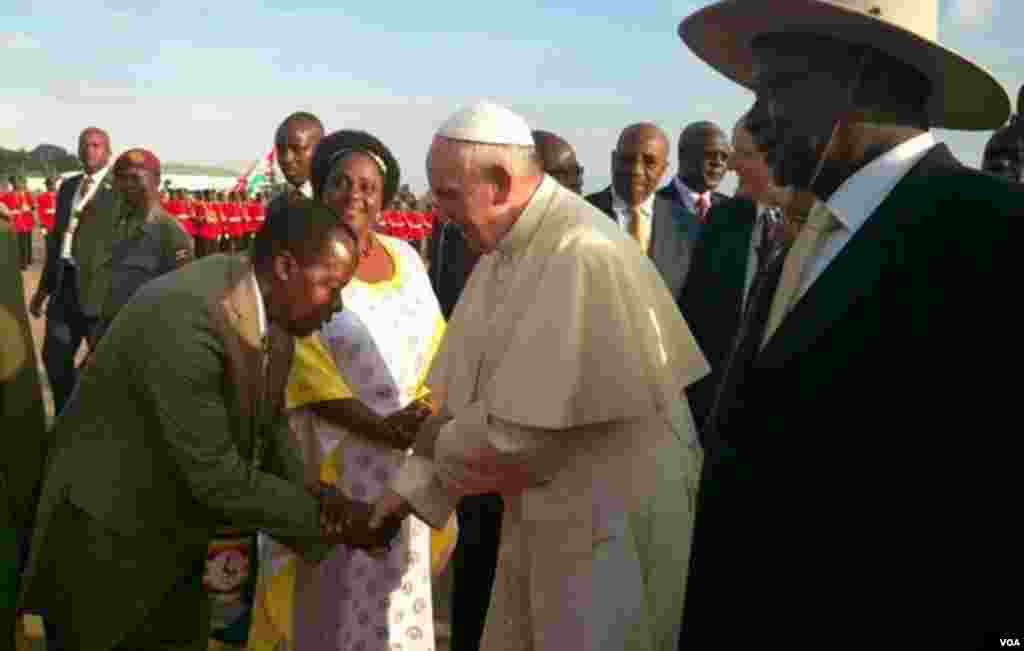 Papa Francis akisalimiwa kwa unyenyekevu na mmoja wa waumini waliofika kumlaki baada ya kuwasili Uganda.