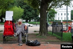 A homeless man sits outside the White House in Washington, U.S., August 2, 2018.