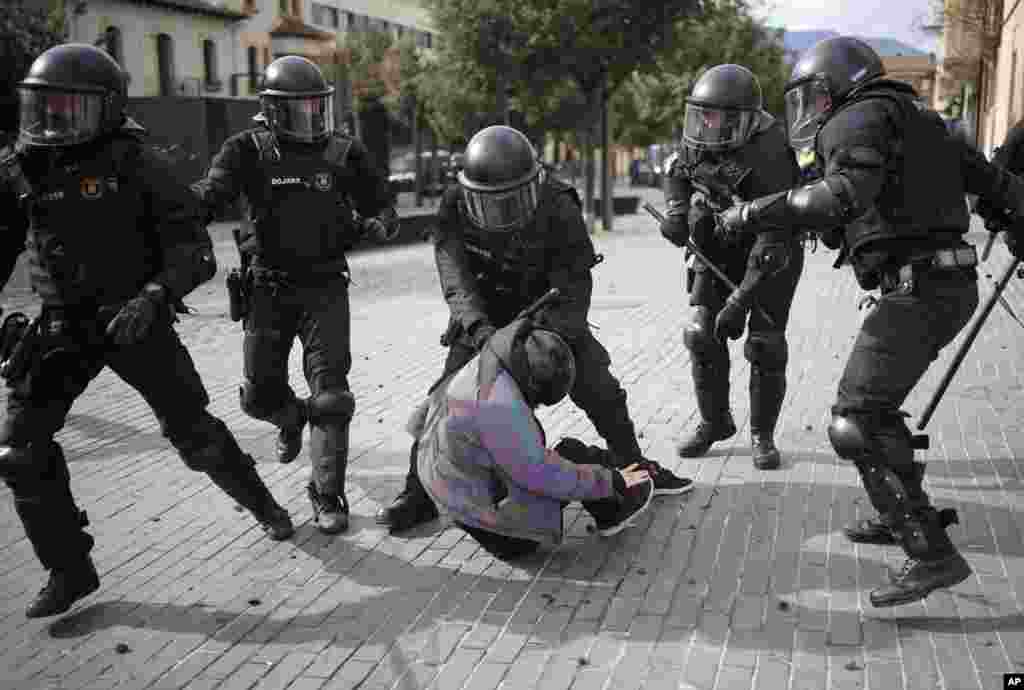 A demonstrator is detained by police officers during a protest against Spain&#39;s far-right Vox party supporters in Olot city, in Girona province.