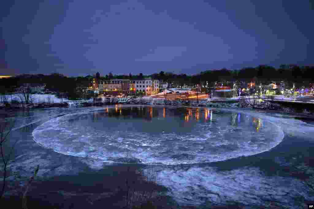 A large ice disk slowly rotates in the Presumpscot River in Westbrook, Maine.