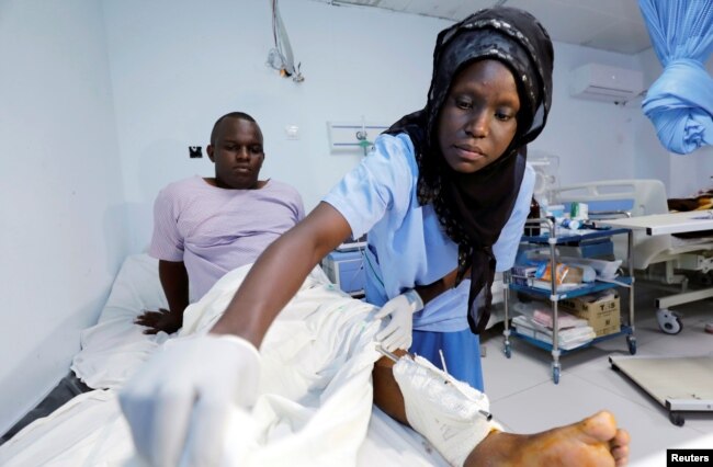 A paramedic at Kalkaal hospital attends to a man injured during a suicide bomb attack near the Sahafi Hotel in Mogadishu, Somalia, Nov. 10, 2018.