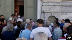 Những khách hàng đầu tiên, hầu hết là những người đã về hưu, xếp hàng chờ đợi trước một chi nhánh của Ngân hàng Quốc gia Hy Lạp tại Athens, Thứ Hai, ngày 20 tháng 7, 2015.