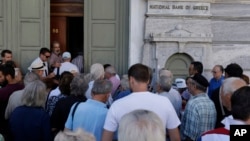 20일 다시 문을 연 그리스 아테네의 은행 문 앞에서 사람들이 줄을 서서 들어가고 있다.
