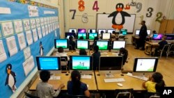 FILE - Elementary students work on computers in Los Angeles, May 15, 2012.