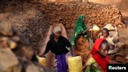 FILE - Women and girls collect water from a well near Marsabit in northern Kenya, Sept. 16, 2014. Marsabit is often hit by prolonged drought, with many families losing livestock in its mainly pastoralist economy. A rural entrepreneurship program is helping women beat extreme poverty by providing business and life-skills training.