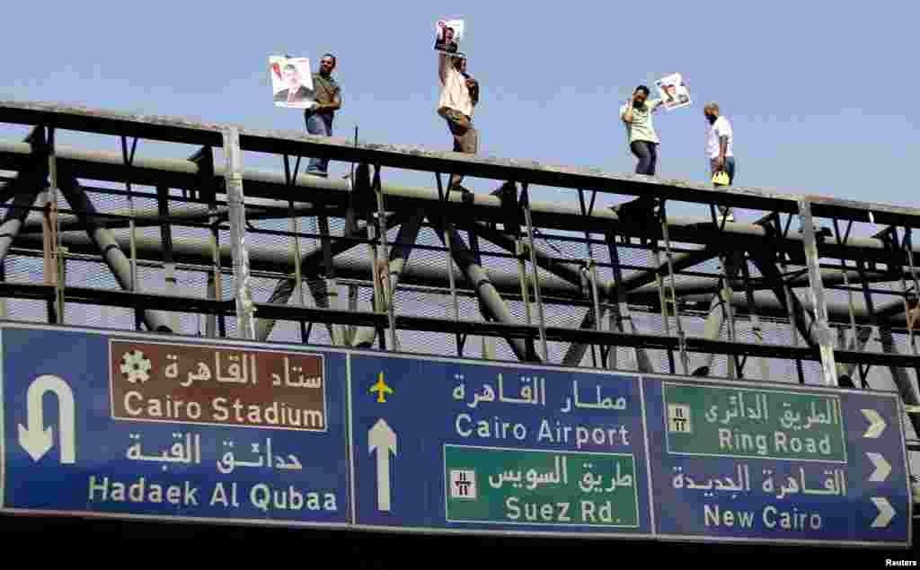 Members of the Muslim Brotherhood and supporters of ousted Egyptian President Mohamed Morsi atop a bridge during a rally around Rabaa Adawiya Square, Cairo July 26, 2013.