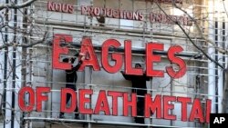 Workers set up ahead a Tuesday's concert by Eagles of Death Metal, at the Olympia music hall, in Paris, Tuesday, Feb. 16, 2016.