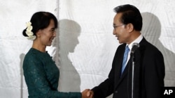 South Korean President Lee Myung-bak, right, shakes hands with Burma opposition leader Aung San Suu Kyi in Rangoon, May 15, 2012.